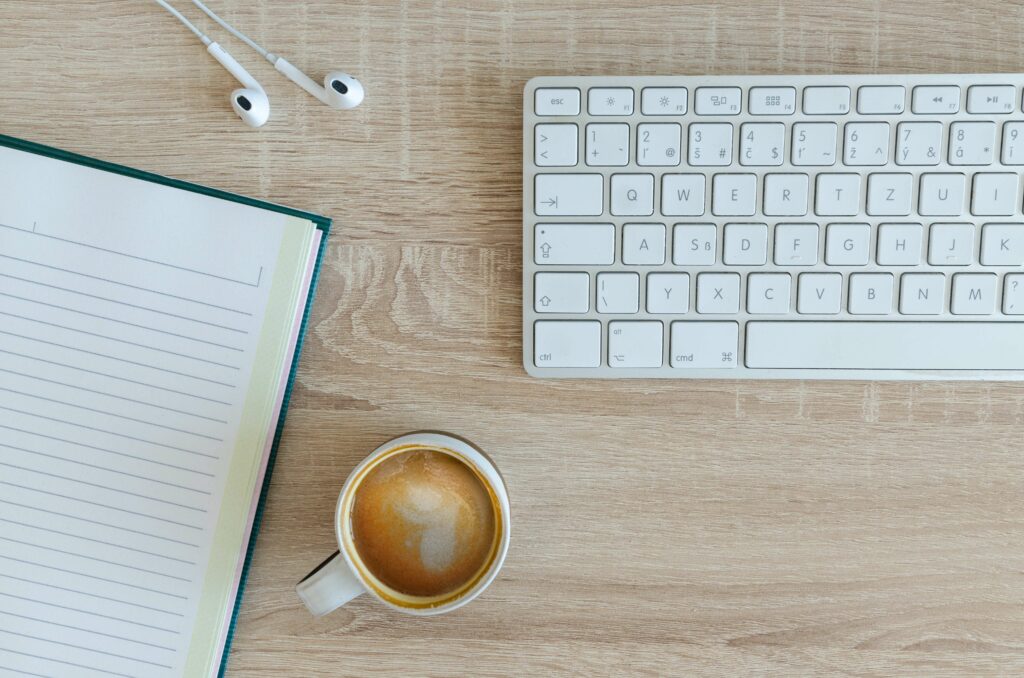 Le bureau d'un freelance avec un café, un agenda et un ordinateur.