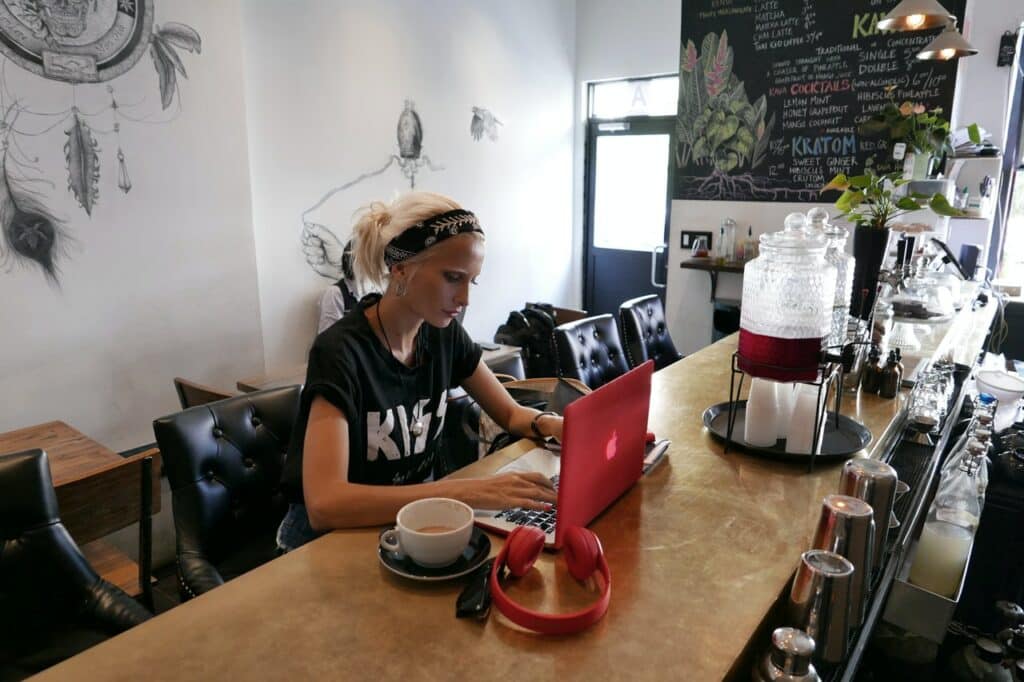 Femme travaillant sur son ordinateur depuis un café